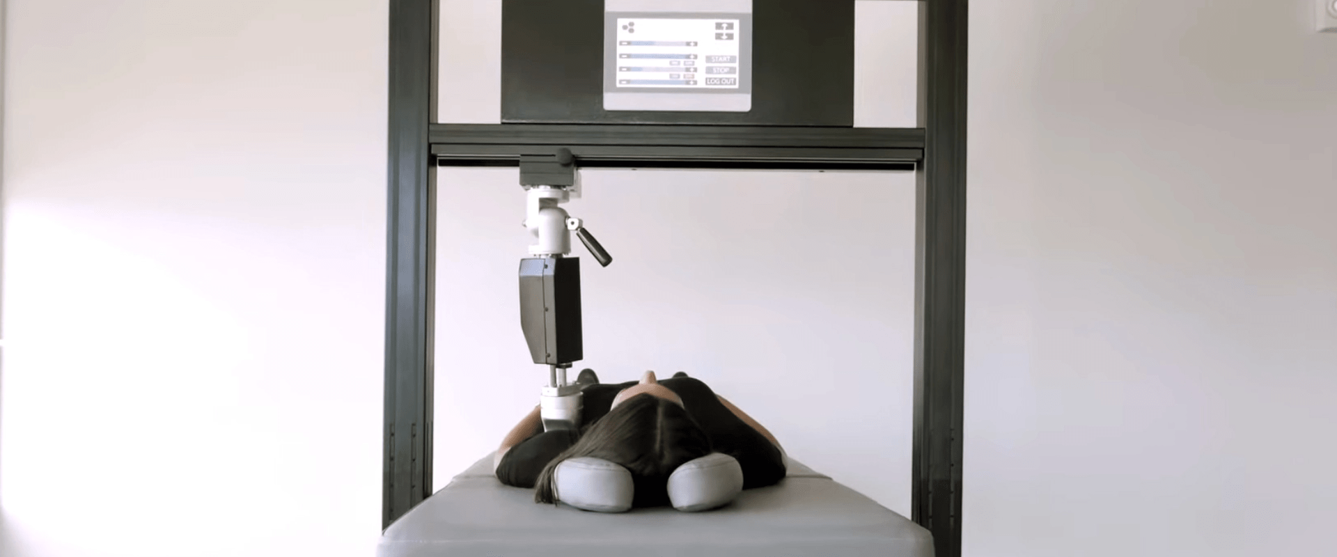 Female patient laying on bed with robotic therapy providing shoulder pain relief